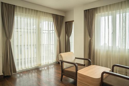 a hospital room with a table and chairs and large windows at Hotel Arjay Valley, Pure Veg Luxury Hotel in Darjeeling