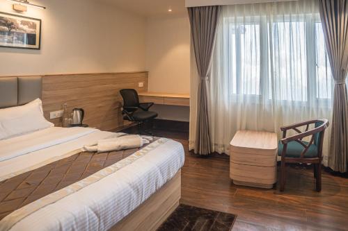 a hotel room with a bed and a chair at Hotel Arjay Valley, Pure Veg Luxury Hotel in Darjeeling