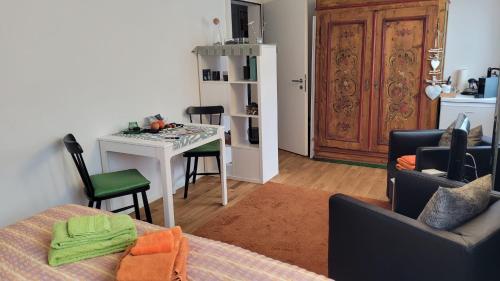 a living room with a table and chairs and a kitchen at Vreneli in Mitlödi