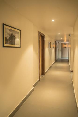 a hallway with white walls and a picture on the wall at Hotel Arjay Valley, Pure Veg Luxury Hotel in Darjeeling