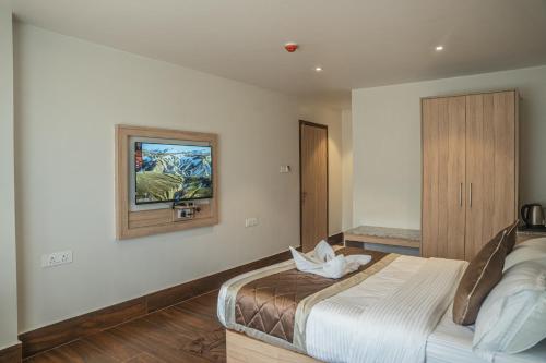 a bedroom with a bed and a picture on the wall at Hotel Arjay Valley, Pure Veg Luxury Hotel in Darjeeling