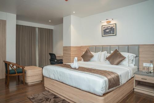 a hotel room with a large bed and a desk at Hotel Arjay Valley, Pure Veg Luxury Hotel in Darjeeling