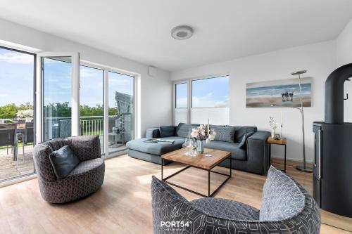 a living room with a couch and chairs and a table at Ferienhaus Saltkrokan Olpenitz in Olpenitz