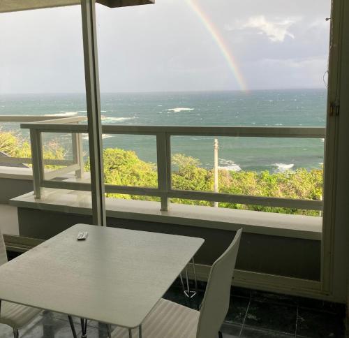 a table and chairs in a room with a rainbow at sunset hills - Vacation STAY 21373v in Hamada