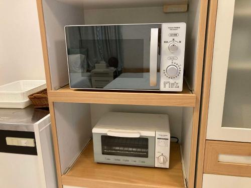 a microwave and a toaster oven on a shelf at sunset hills - Vacation STAY 21373v in Hamada