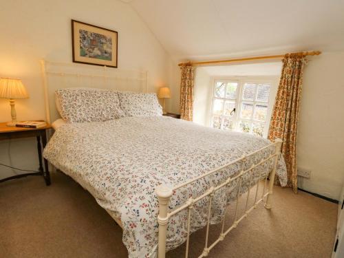 a bedroom with a white bed and a window at Little Orchard in Thorncombe
