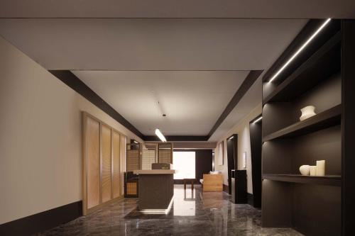 a lobby with a hallway with black walls and a counter at The S Heartland Hotel Chengdu（by Taikoo Li） in Chengdu