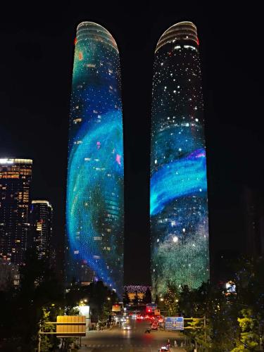 two tall buildings are lit up at night at The S Heartland Hotel Chengdu（by Taikoo Li） in Chengdu