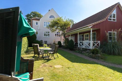 a house with a table and chairs in the yard at Lütt Drosselhörn 2 in Laboe