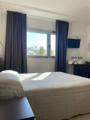 a bedroom with a large bed and a window at Hotel Ulisse in Marina Romea