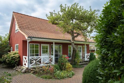 a red house with a red roof at Lütt Drosselhörn 1 in Laboe