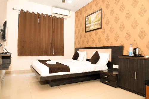 a bedroom with a bed with white sheets and pillows at Hotel De Agya Paradise best hotel at ludhiana railway station in Ludhiana