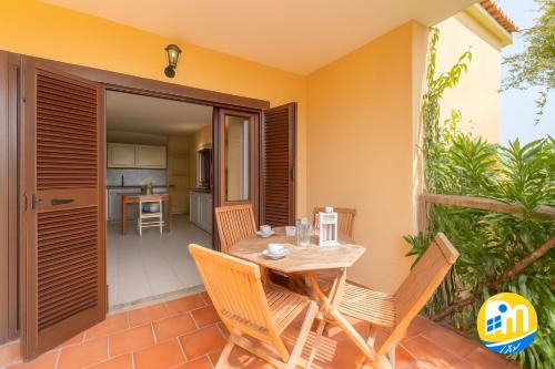 a patio with a table and chairs and a kitchen at Relaxing Baia De Bahas seaview 1Bedroom Apartment B4 sleeps 4 in Marinella