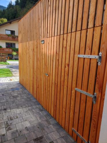 a wooden fence with two doors on it at Apartma Discovering Slovenia in Luče