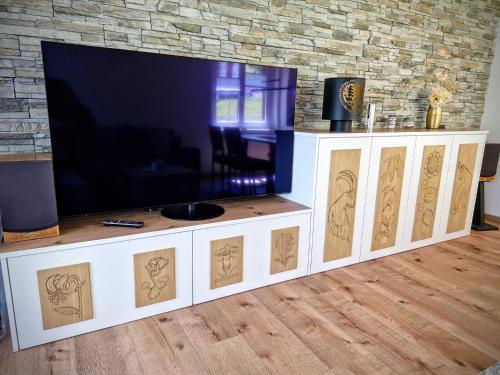 a flat screen tv on a white entertainment center at Ferienwohnung Valere B - it's magic gmbh in Leukerbad