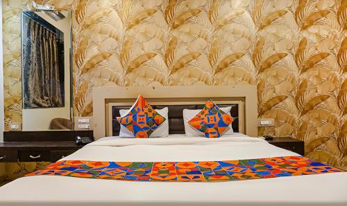 a bedroom with a large bed with colorful pillows at Hotel Shades of Royal in Ahmadnagar