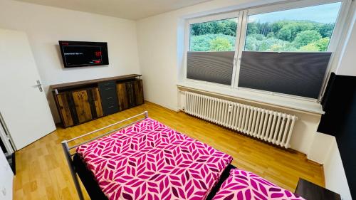 a room with a large window and a pink bed at Apartment Osnabrück Haste in Osnabrück