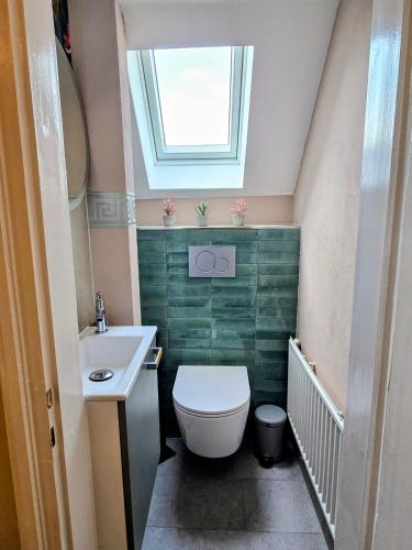 a bathroom with a toilet and a sink and a window at HR Haus unter den Linden in Coesfeld