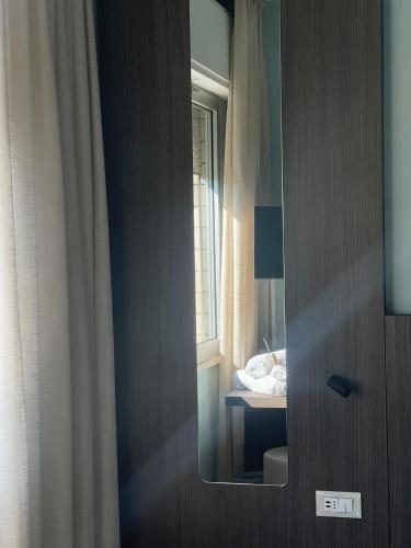 a mirror on the door of a bedroom at Hotel Ulisse in Marina Romea