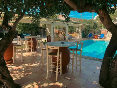 un patio con tavolo e sedie e una piscina di Ammoudara Beach Hotel Apartments ad Ágios Nikólaos