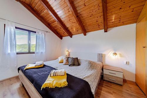 una camera da letto con un letto grande e una finestra di Holiday house Ivan with heated pool a Potirna