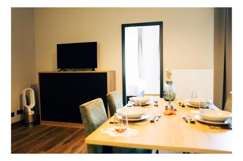 a dining room table with chairs and a television at Residency NO7 in Berlin