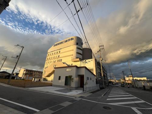 a building on the side of a street with a crosswalk at 彦根びわこホテル裏のマンション 一室貸し切り50台無料駐車場付き台所あり自転車貸出可 BbQ可 ペット同伴可 in Hikone