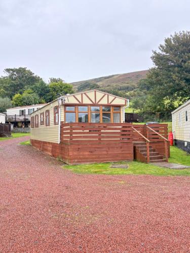 a tiny house sitting on the side of a road at Cosy Caravan by the sea in Cairnryan
