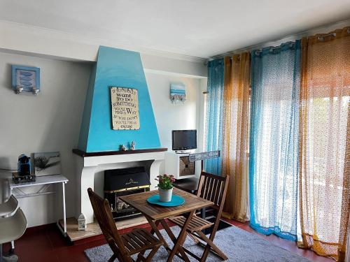 a living room with a table and chairs and a fireplace at Casa da Areia Branca in Bolembre de Baixo