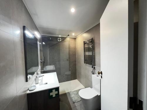 ein Badezimmer mit Waschbecken, Toilette und Spiegel in der Unterkunft Casa da Areia Branca in Bolembre de Baixo