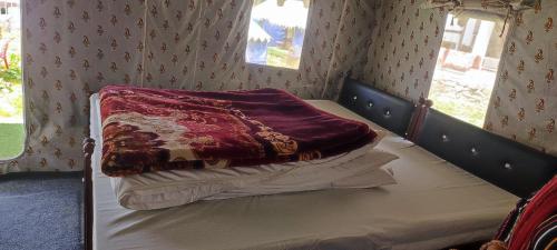 a bed with a blanket on it in a room at Chopta Rock Hill Camp in Chopta