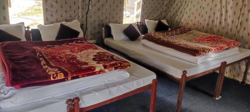 two beds sitting next to each other in a room at Chopta Rock Hill Camp in Chopta