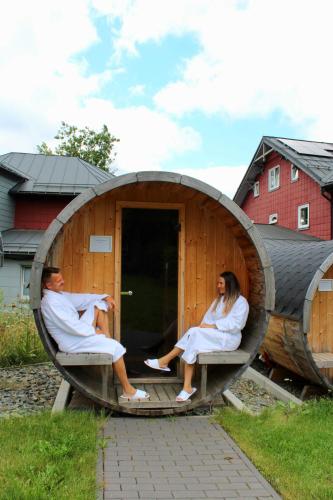 a man and woman sitting in a barrel house at Konsum Berghotel Oberhof in Oberhof