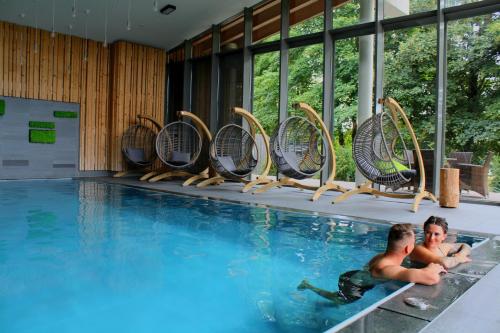 two men swimming in a swimming pool at Konsum Berghotel Oberhof in Oberhof