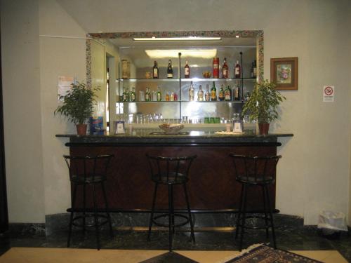a bar with two stools in front of a mirror at Hotel Niagara Rimini in Rimini