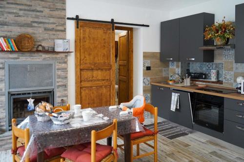 a kitchen with a table and chairs and a kitchen with a fireplace at La casa di Astrid vacation home in Bussoleno