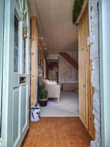 a hallway of a house with a door and a couch at Waterfall retreat in Blaenau-Ffestiniog