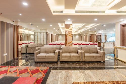 a lobby with couches and a bed in the background at Treebo Premium Gateway Triveni in Prayagraj