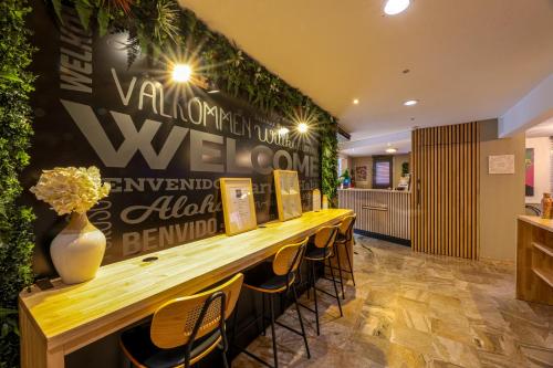 a long table with chairs and a wall with plants at Ostal Pau Universite - Sure Hotel Collection by Best Western in Pau