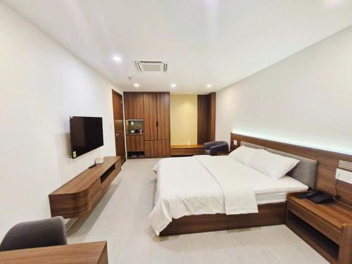 a bedroom with a bed and a flat screen tv at Lumia Hotel in Ho Chi Minh City