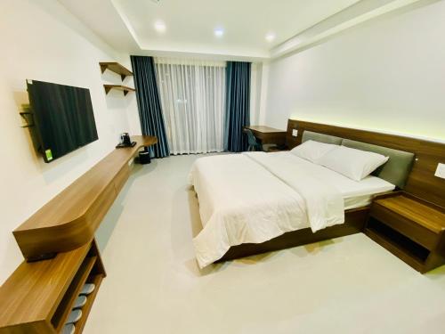 a bedroom with a bed and a television in it at Lumia Hotel in Ho Chi Minh City