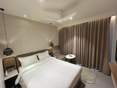 a bedroom with a large white bed and a window at 7 Apple Hotel Vizag, Visakhapatnam in Dāpuri