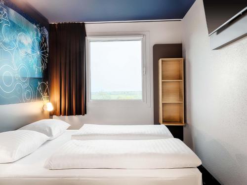 ガルヒング・バイ・ミュンヘンにあるB&B Hotel München-Garchingの窓のある小さな部屋にベッドが2つある