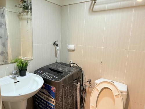 a small bathroom with a toilet and a sink at Premiere Haven MOA Staycation in Manila