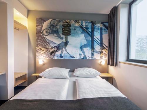 a bedroom with a bed with a picture on the wall at B&B Hotel München-Olympiapark in Munich