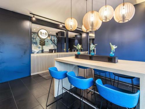 a bar in a restaurant with blue stools at B&B Hotel München-Olympiapark in Munich
