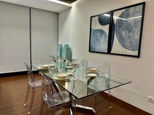 a dining room with a glass table and chairs at Azores Pico Salomão T2 - AW in Ponta Delgada