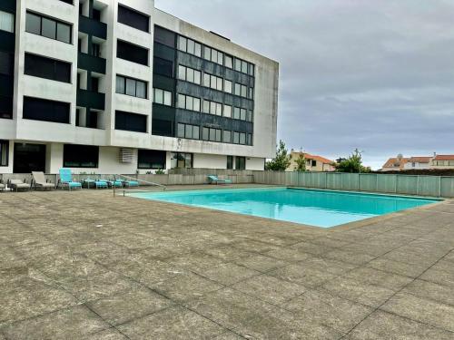 an empty swimming pool in front of a building at Azores Pico Salomão T2 - AW in Ponta Delgada