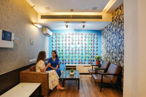 two women sitting on a couch in a waiting room at FabHotel Kaushambi in Ghaziabad