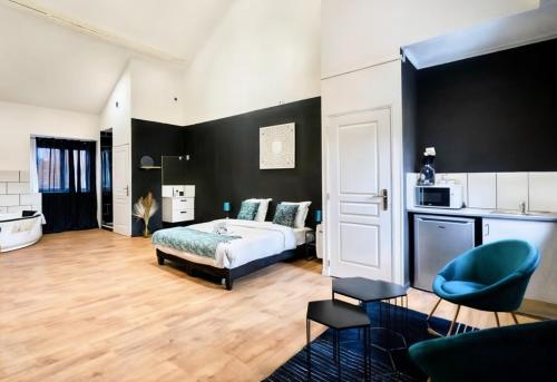 a bedroom with a bed and a blue chair at Suite Balnéo Privée Design Calme Proche Lille in Roubaix